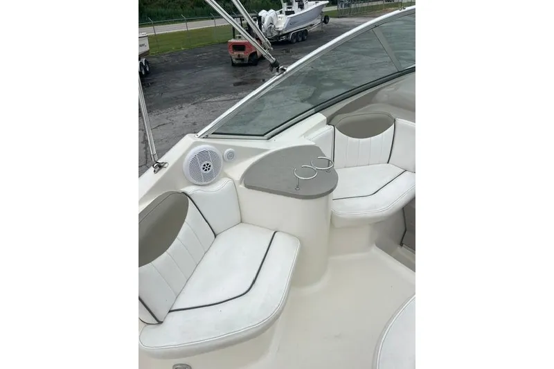 Slide: The Image of 2006 Sea Ray 240 Sundancer boat interior with white seating and cup holders. - 15