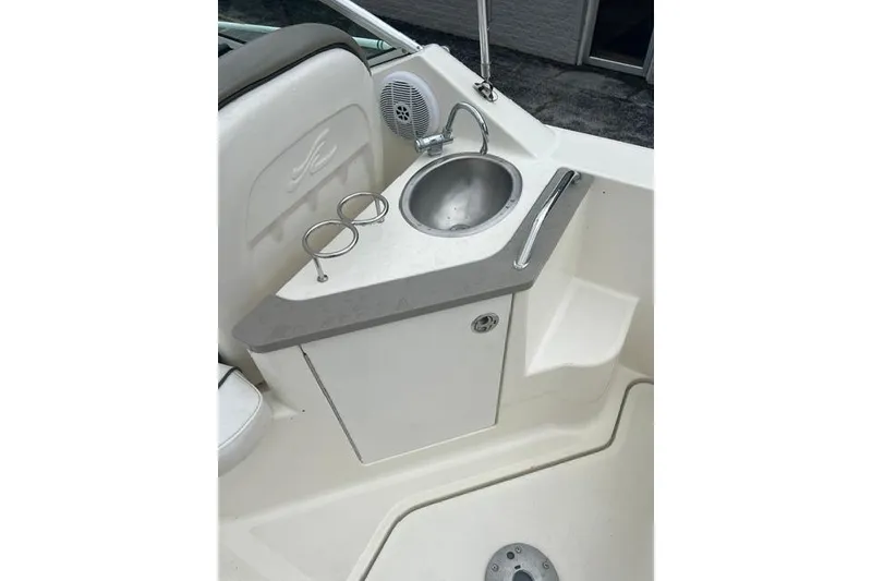 Slide: The Image of 2006 Sea Ray 240 Sundancer boat interior with sink and cup holders. - 14