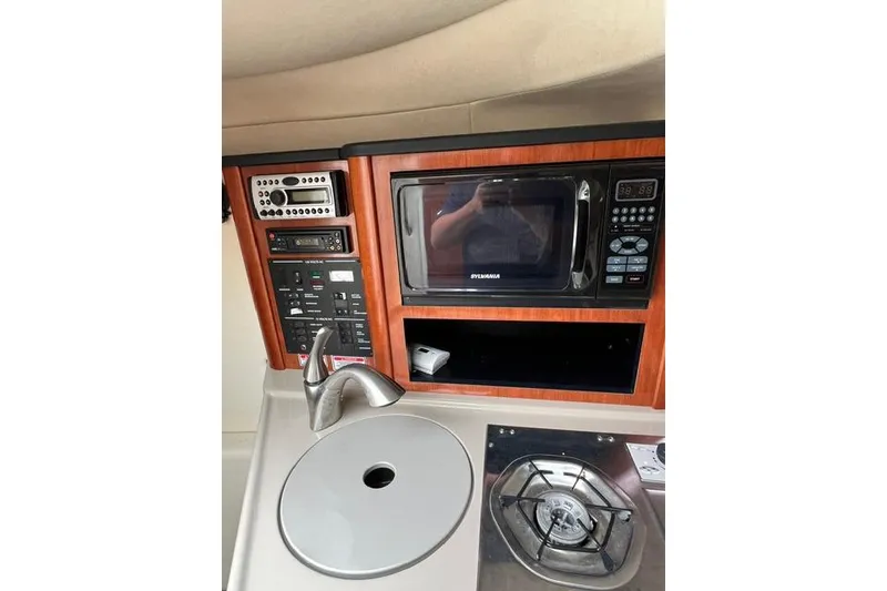Slide: The Image of 2006 Sea Ray 240 Sundancer galley with microwave, sink, and stove. - 4