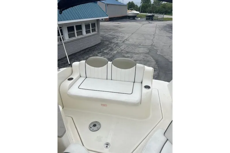 Slide: The Image of 2006 Sea Ray 240 Sundancer boat with white seating and cup holders on deck. - 17