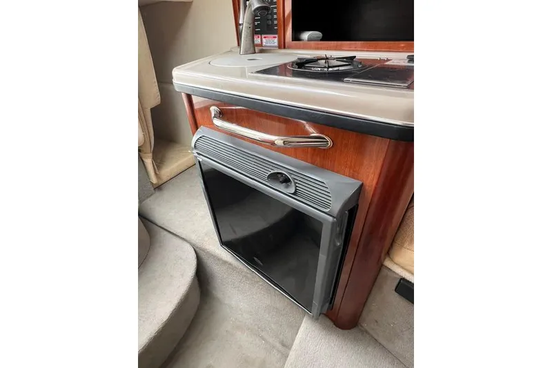 Slide: The Image of 2006 Sea Ray 240 Sundancer cabin with compact kitchen and mini fridge. - 5
