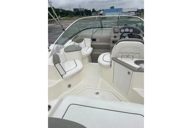 Slide: The Image of 2006 Sea Ray 240 Sundancer boat interior with seating and helm, showcasing luxury design. - 16