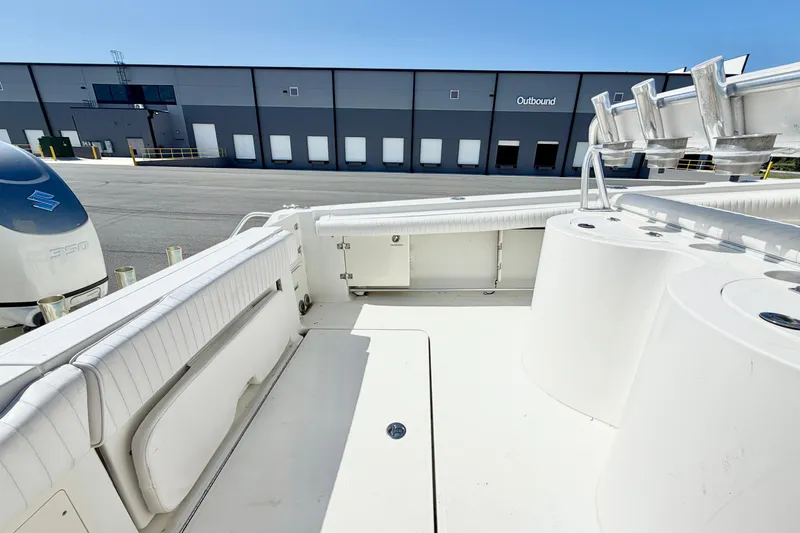 Slide: The Image of 2004 Hydra-Sports Vector 3300 CC boat interior with seating and rod holders, docked near a warehouse. - 10