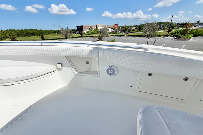 Slide: The Image of 2004 Hydra-Sports Vector 3300 CC boat interior with white seating and speaker, parked outdoors. - 17
