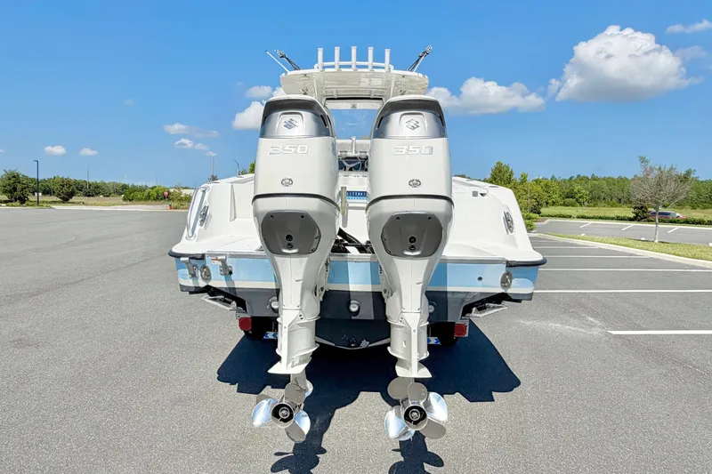 Slide: The Image of 2004 Hydra-Sports Vector 3300 CC with dual Suzuki 350 outboard engines in a parking lot. - 3