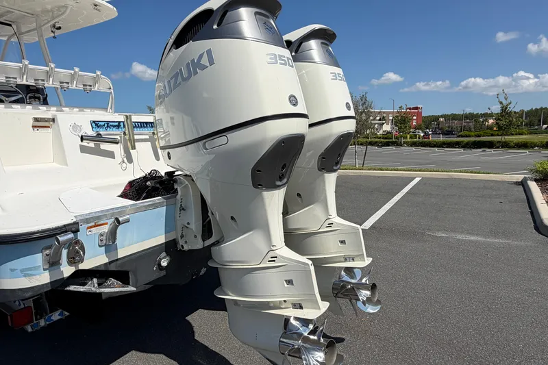 Slide: The Image of 2004 Hydra-Sports Vector 3300 CC with dual Suzuki 350 outboard motors in a parking lot. - 2