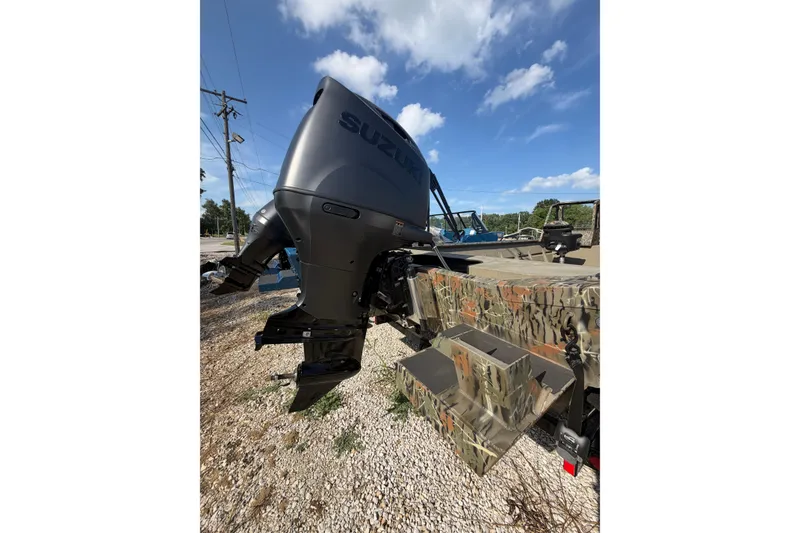 Slide: The Image of 2025 SeaArk 2272 MVT boat with Suzuki outboard motor, camo design, under clear blue sky. - 5