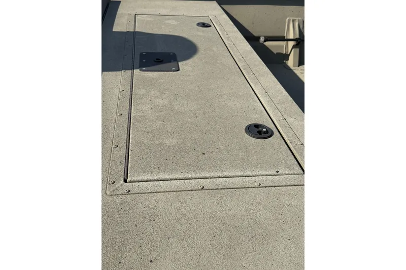 Slide: The Image of 2025 SeaArk 2272 MVT boat deck with storage hatch and latch details. - 8