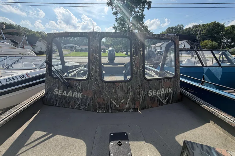 The Image of 2025 SeaArk 2272 MVT boat with camouflage design, docked under a sunny sky. - 0