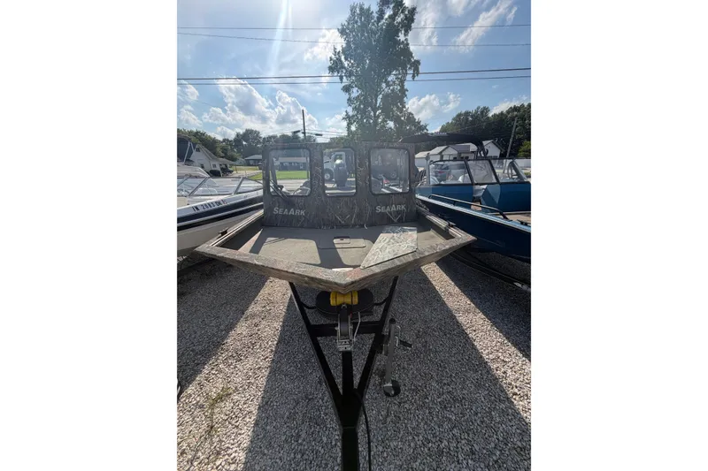 Slide: The Image of 2025 SeaArk 2272 MVT boat on trailer, parked outdoors under a sunny sky. - 2