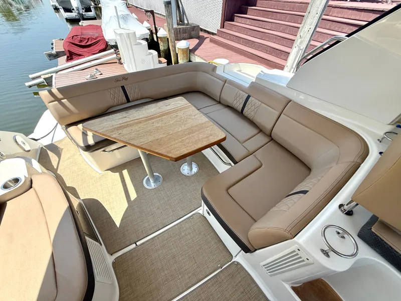Slide: The Image of The image shows the seating area of a 2017 Sea Ray Sundancer 350 Coupe with a wooden table. - 8