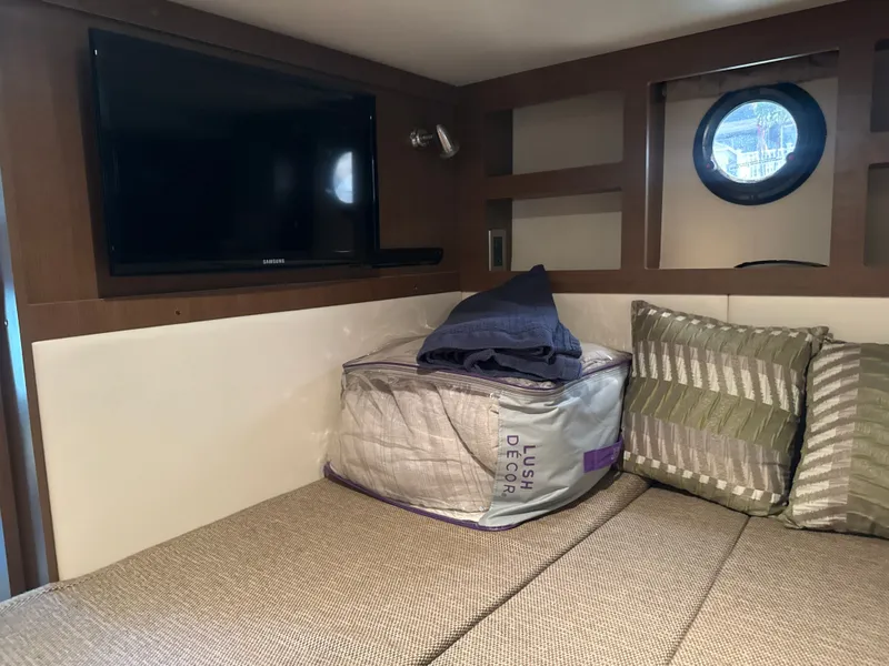Slide: The Image of Interior of a 2017 Sea Ray Sundancer 350 Coupe with bed, cushions, and TV. - 36