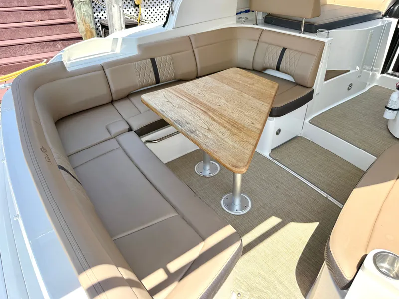 Slide: The Image of Interior of a Sea Ray Sundancer 350 Coupe with beige seating area and wooden table. - 9
