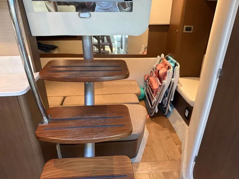 Slide: The Image of Interior of the 2017 Sea Ray Sundancer 350 Coupe with wooden steps and seating area. - 34