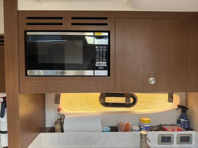 Slide: The Image of The galley of a 2017 Sea Ray Sundancer 350 Coupe with a microwave and storage. - 22