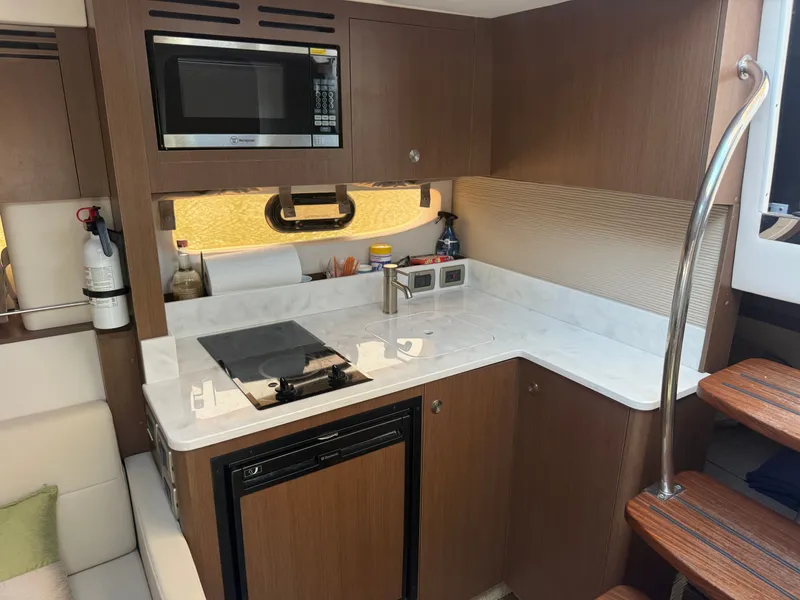Slide: The Image of The galley of a 2017 Sea Ray Sundancer 350 Coupe with a microwave and stove. - 21