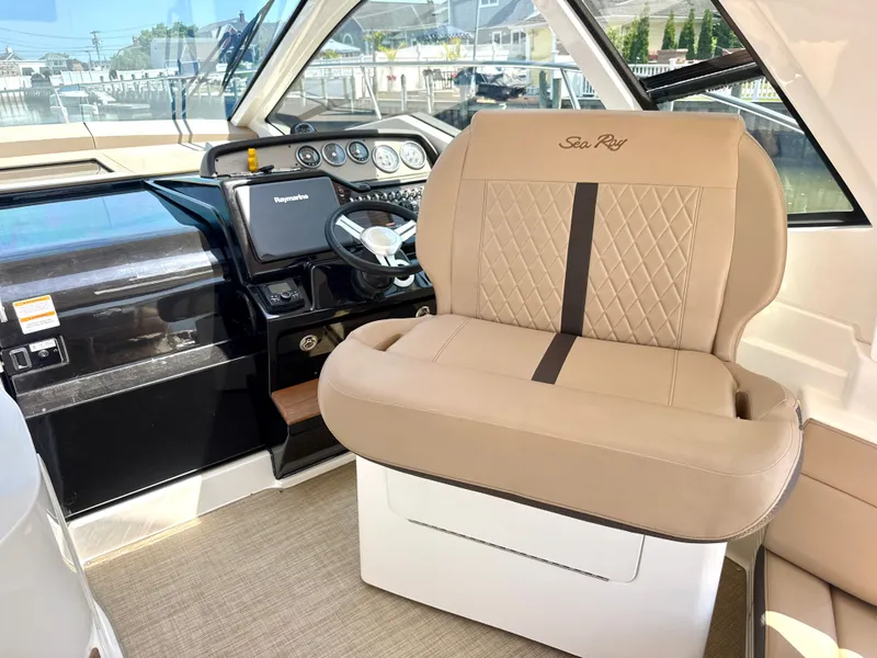 Slide: The Image of Interior of a 2017 Sea Ray Sundancer 350 Coupe with beige seating and helm console. - 18