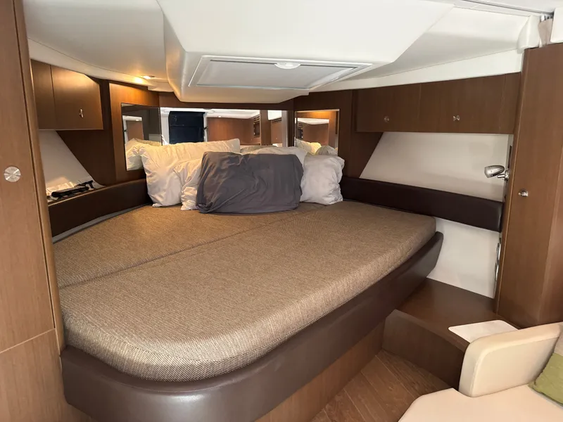 Slide: The Image of Interior of the 2017 Sea Ray Sundancer 350 Coupe with cozy bed and wooden furnishings. - 29