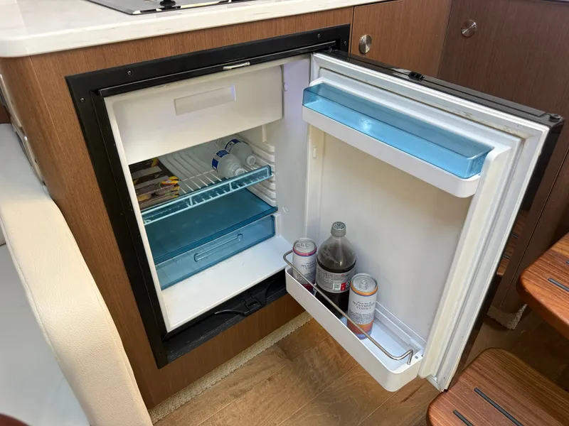 Slide: The Image of An open fridge in a boat cabin with drinks and snacks. - 24