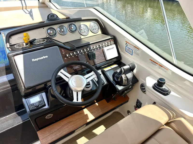 Slide: The Image of The cockpit of a 2017 Sea Ray Sundancer 350 Coupe with modern instruments and controls. - 16