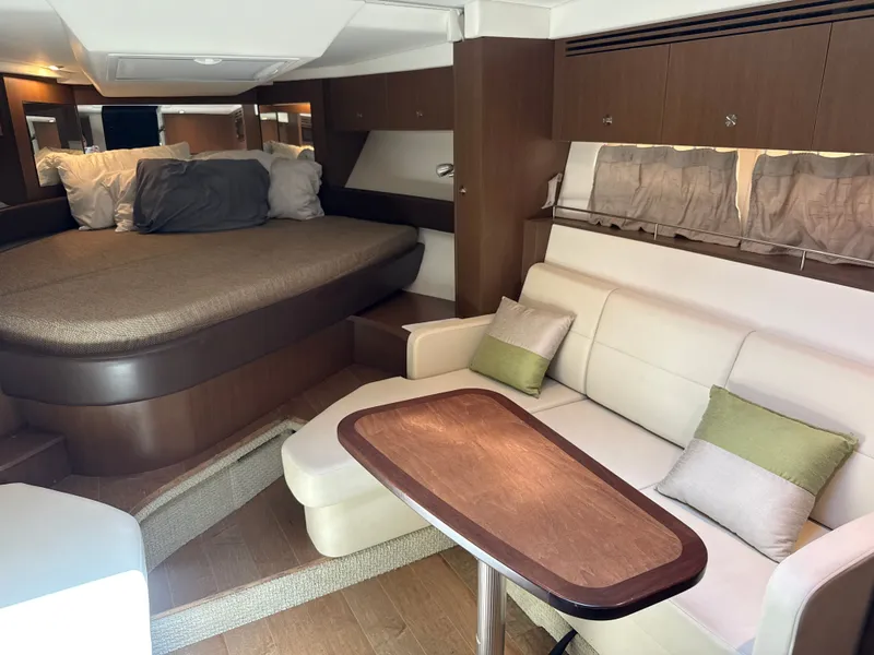 Slide: The Image of Interior of the 2017 Sea Ray Sundancer 350 Coupe with sofa, table, and sleeping area. - 28