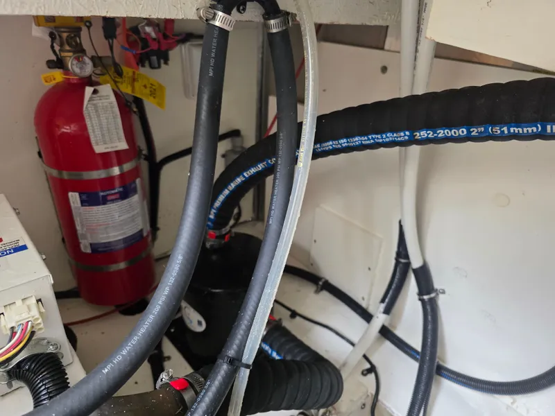 Slide: The Image of A view inside the engine compartment of a 2017 Sea Ray Sundancer 350 Coupe with hoses and a fire extinguisher. - 48