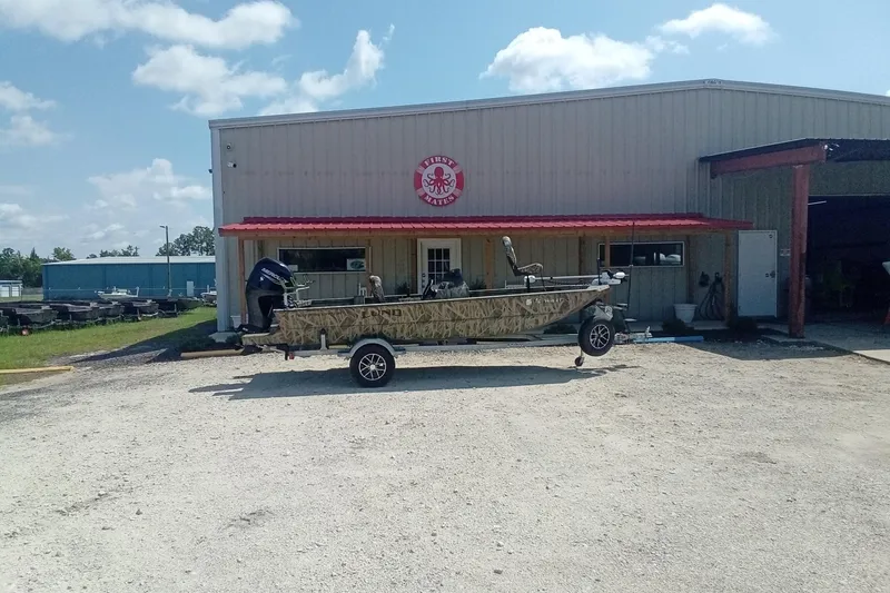 Slide: The Image of 2025 Lund 1760 Predator SC boat parked outside a dealership under a clear sky. - 5