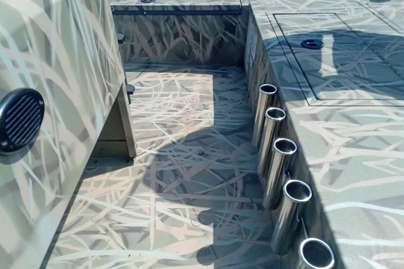 Slide: The Image of 2025 Lund 1760 Predator SC boat interior with camo design and rod holders. - 14
