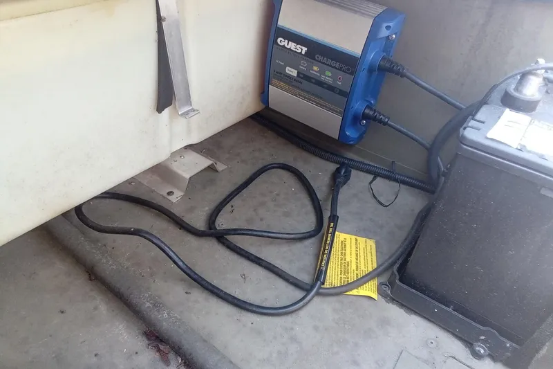 Slide: The Image of Battery charger setup in a 2025 Lund 1760 Predator SC boat interior. - 26