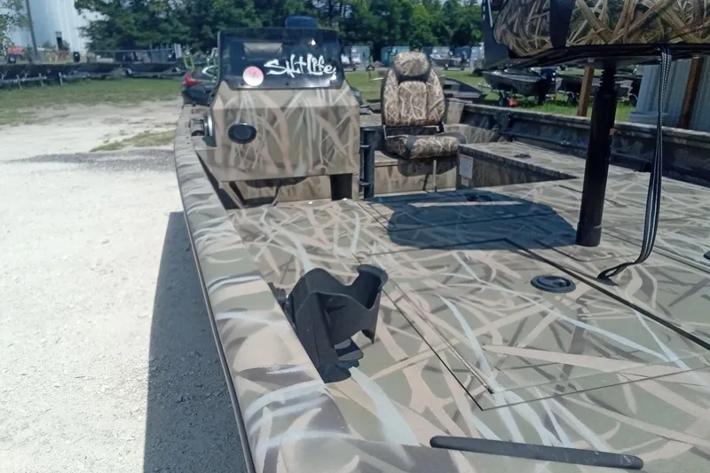 Slide: The Image of 2025 Lund 1760 Predator SC boat with camouflage design, featuring seating and console. - 13