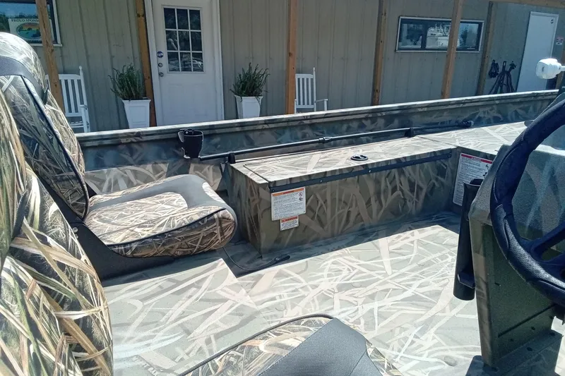 Slide: The Image of 2025 Lund 1760 Predator SC boat interior with camouflage seating and steering wheel. - 19