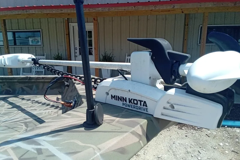 Slide: The Image of Minn Kota PowerDrive motor on 2025 Lund 1760 Predator SC boat, parked outside a building. - 11