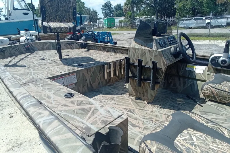 Slide: The Image of 2025 Lund 1760 Predator SC boat with camouflage interior, parked outdoors. - 23