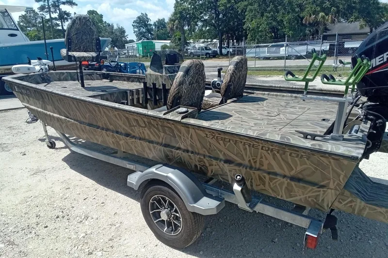 Slide: The Image of 2025 Lund 1760 Predator SC boat with camouflage design on a trailer. - 22
