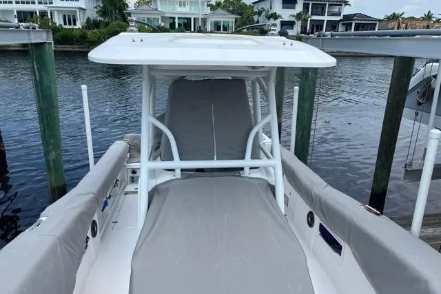 Slide: The Image of 2023 Seafox 268 boat docked by waterfront homes, featuring cushioned seating and T-top. - 9