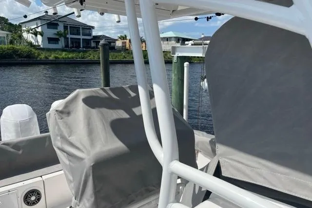 Slide: The Image of 2023 Seafox 268 boat docked by waterfront homes, covered seats, sunny day. - 12