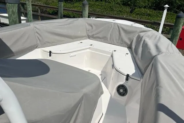 Slide: The Image of 2023 Seafox 268 boat interior with gray covers, docked at a marina. - 11