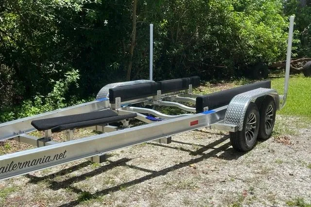 Slide: The Image of Trailer for 2023 Seafox 268 boat, parked on gravel with lush greenery background. - 8