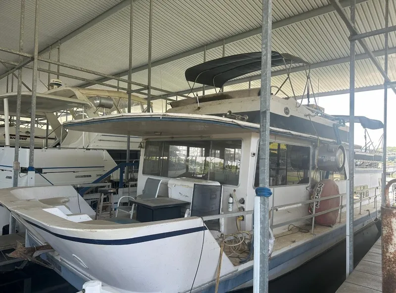 Slide: The Image of A 1989 Gibson Standard 50 houseboat docked in a covered marina. - 1
