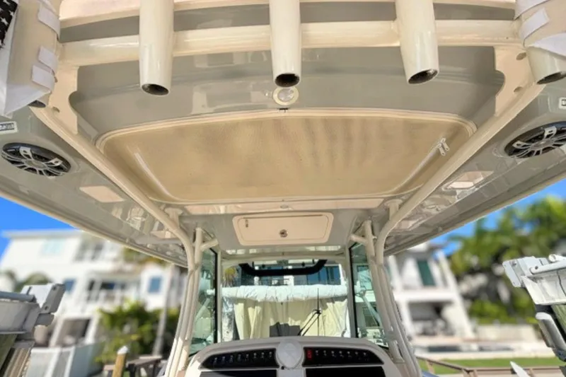 Slide: The Image of 2025 Grady-White Canyon 336 boat interior, featuring rod holders and speakers. - 20