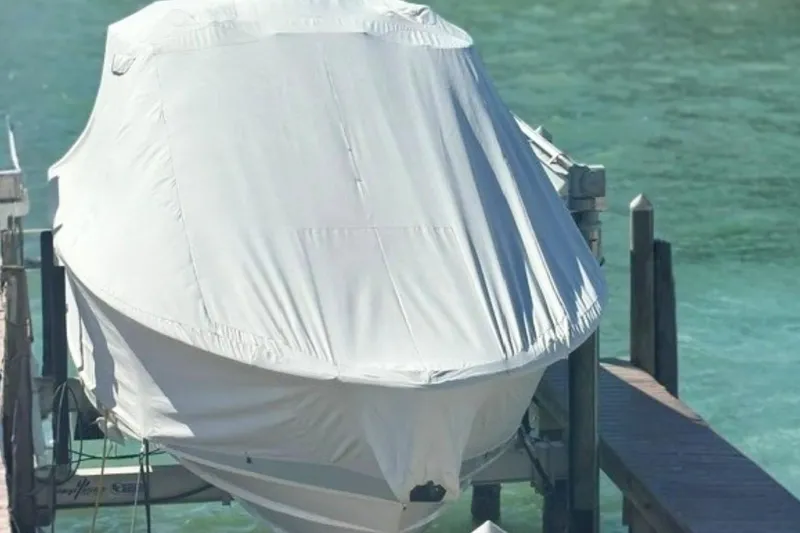 Slide: The Image of Covered 2025 Grady-White Canyon 336 boat docked by clear water. - 27