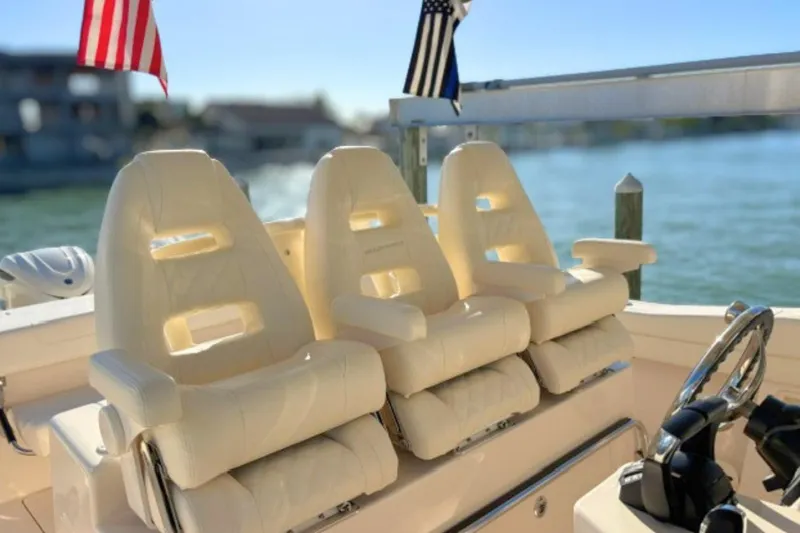 Slide: The Image of Luxurious seating on 2025 Grady-White Canyon 336 boat with flags in background. - 16