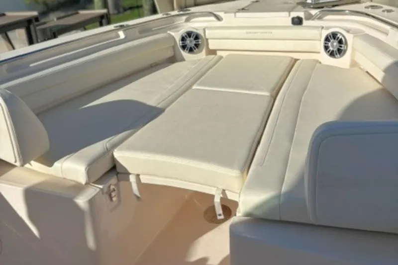 Slide: The Image of 2025 Grady-White Canyon 336 boat interior with cushioned seating and built-in speakers. - 23