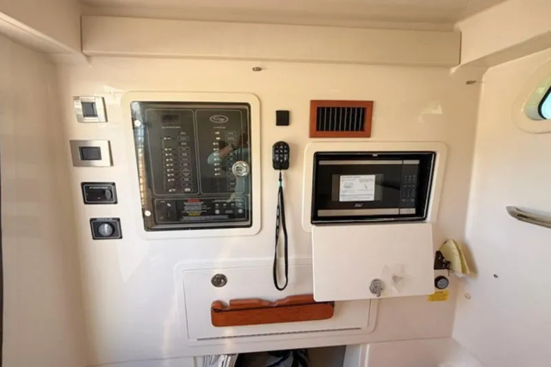 Slide: The Image of Interior control panel of 2025 Grady-White Canyon 336 boat with microwave and communication equipment. - 25