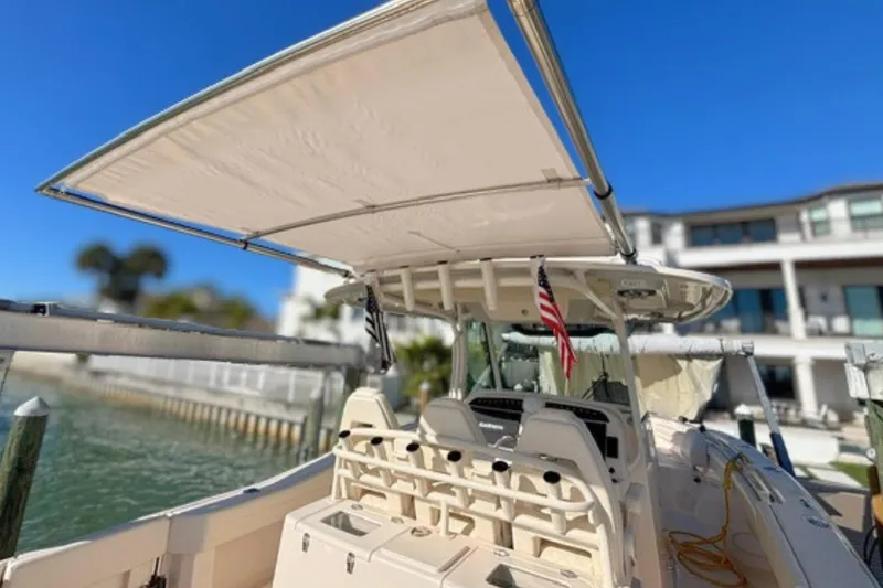 Slide: The Image of 2025 Grady-White Canyon 336 boat with canopy, docked near waterfront property. - 18