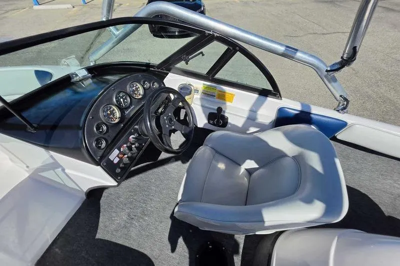 Slide: The Image of 1998 Moomba Outback boat interior with steering wheel, gauges, and gray captain's chair. - 8