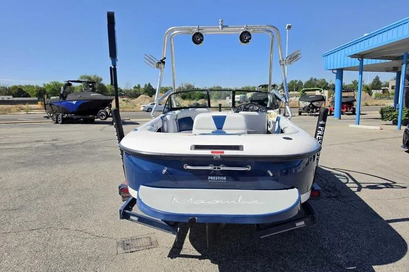 Slide: The Image of 1998 Moomba Outback boat with wakeboard tower in a parking lot. - 12