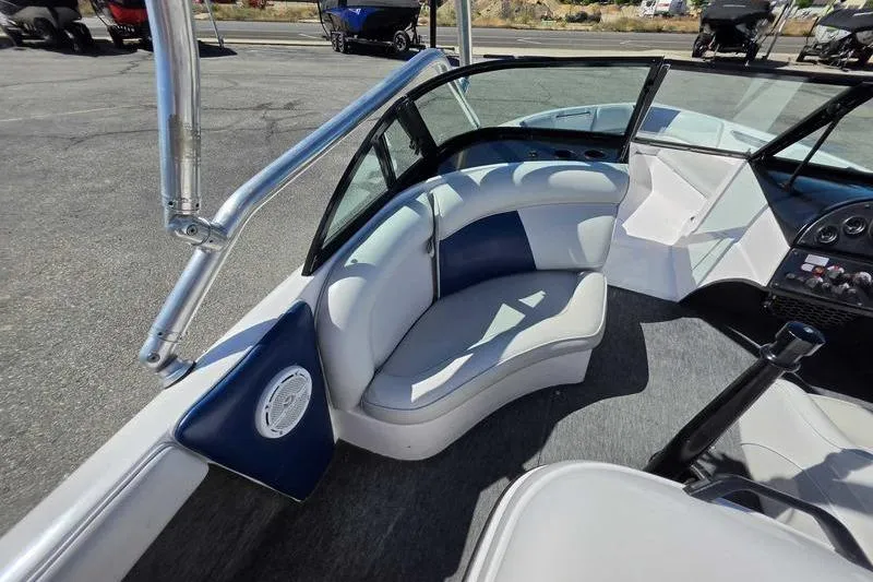 Slide: The Image of 1998 Moomba Outback boat interior with white and blue seating, steering console, and speaker. - 7