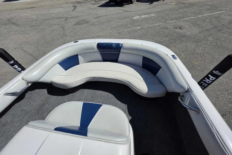 Slide: The Image of 1998 Moomba Outback boat interior with white and blue seating in a parking lot. - 6