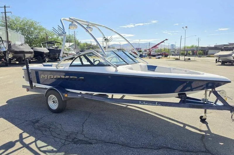 Slide: The Image of 1998 Moomba Outback boat on trailer in sunny outdoor setting. - 16